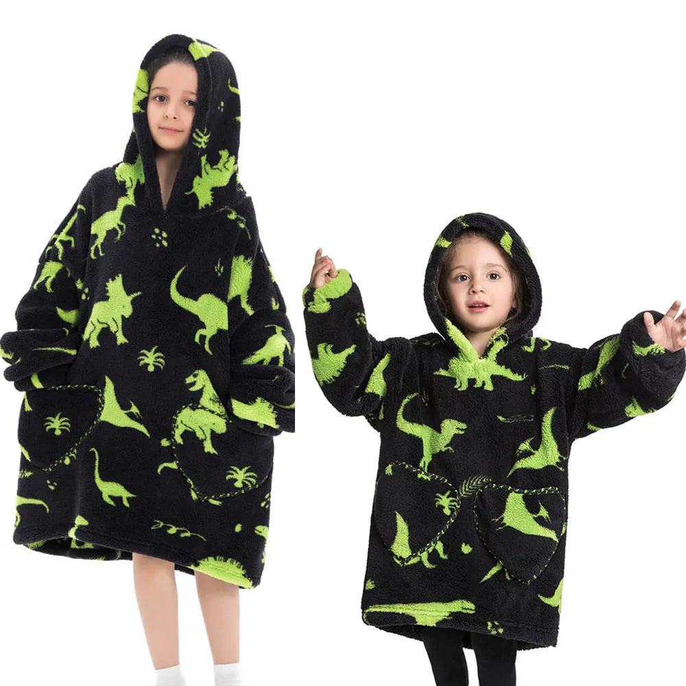 A young girl wearing a black flannel hoodie sweater with green dinosaur print.