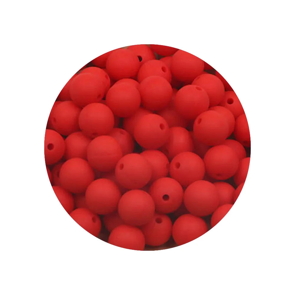 A close-up view of 50 silicone beads in various sizes and shades of red, used for DIY jewelry making.