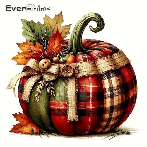A decorative pumpkin with a plaid fabric covering and autumn leaves.