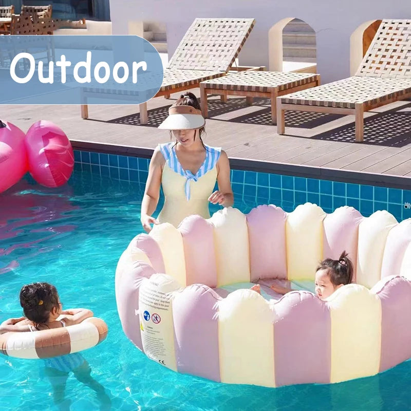 A pink inflatable round toddler pool is floating in clear water outdoors with a child inside.