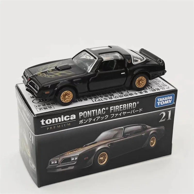 A black Tomica Pontiac Firebird die-cast model car displayed on its packaging.