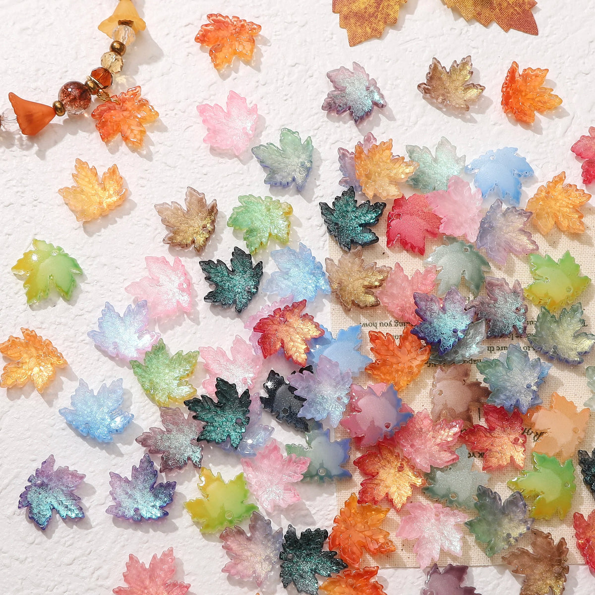 A collection of colorful maple leaf glass beads for DIY jewelry making