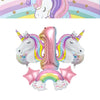 A set of pink and rainbow unicorn balloons shaped like a number one and a rainbow for a birthday celebration