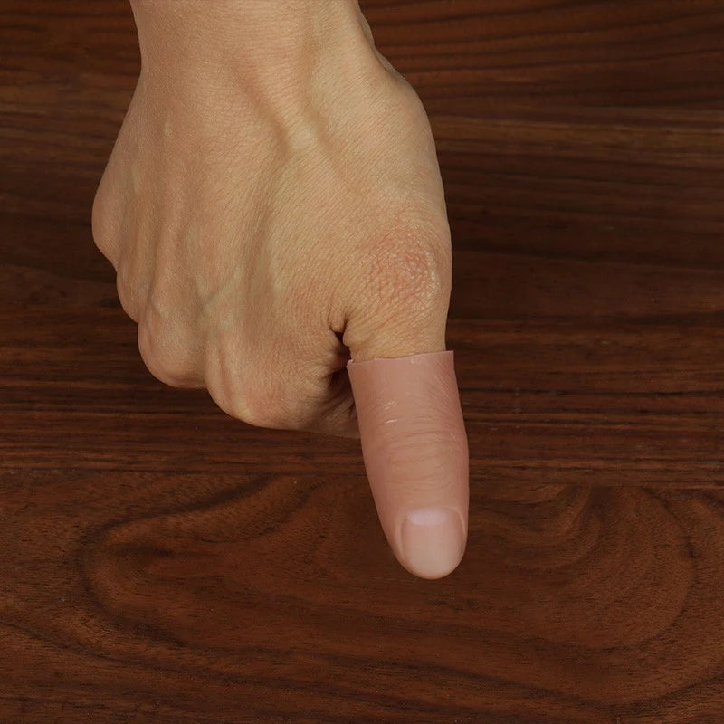 A hand holding a realistic silicone fake thumb tip used for magic tricks