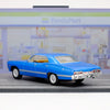 A blue 1967 Chevrolet Impala diecast model car in a pull-back action pose on a gray surface.
