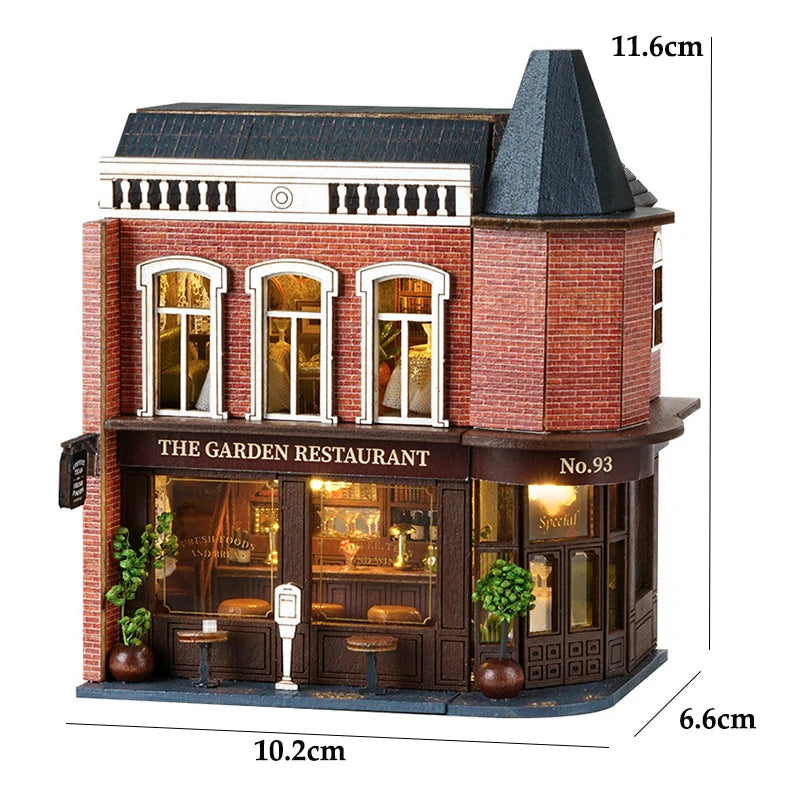 A detailed wooden dollhouse kit of a red brick restaurant building with large windows and a dark roof.