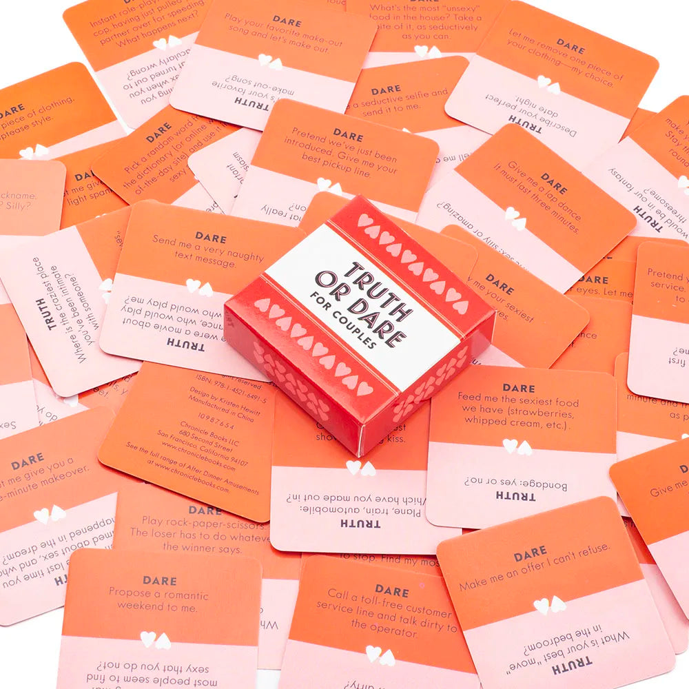 A pile of red and orange Truth or Dare cards for couples with various prompts.