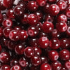 A close-up view of small, round, deep red glass beads for DIY jewelry making.