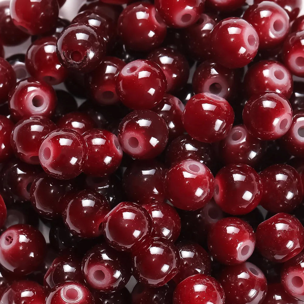 A close-up view of small, round, deep red glass beads for DIY jewelry making.