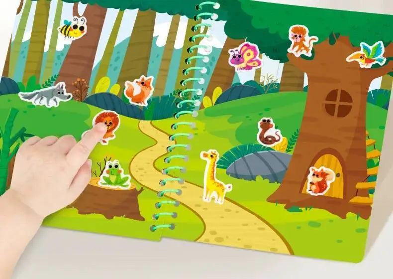 A hand points to a small orange animal on a colorful outdoor scene featuring a tree and a winding path.