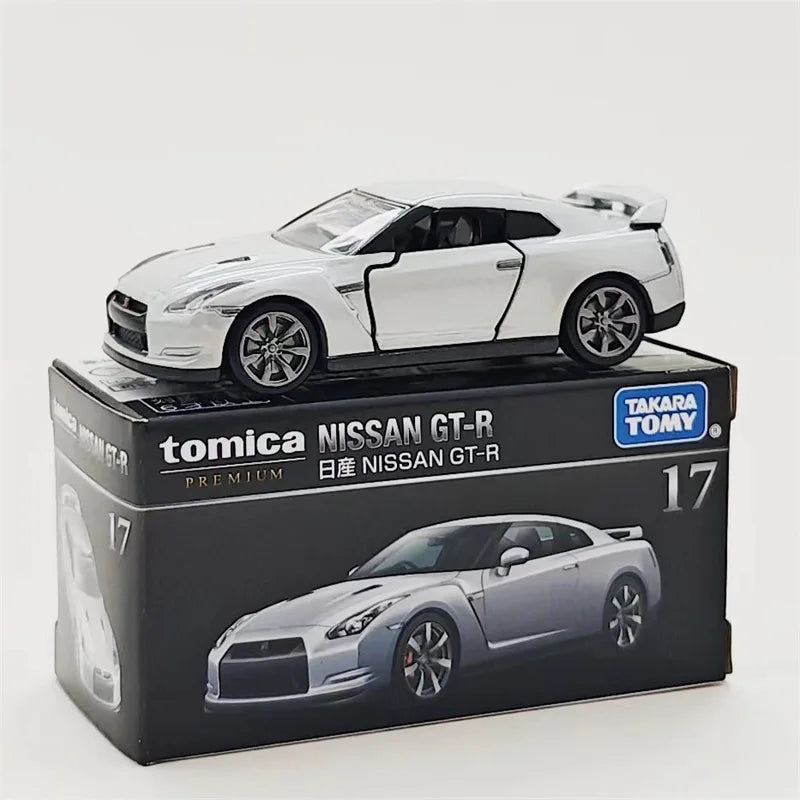 A Tomica Nissan GT-R die-cast model car in silver and black on its packaging.