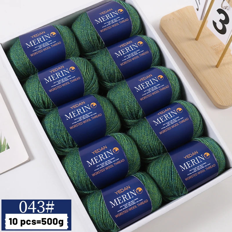 A box of YEDAN MERIN worsted wool thread yarn in green and blue colors for knitting projects.