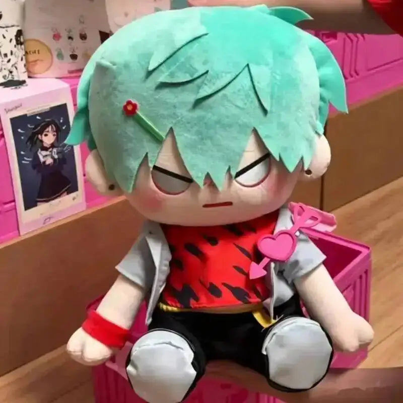A plush doll of an anime character with bright teal hair, wearing a red top and gray clothing.