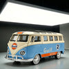 A vintage style metal bus diecast model in light blue and cream colors is displayed under bright lighting.