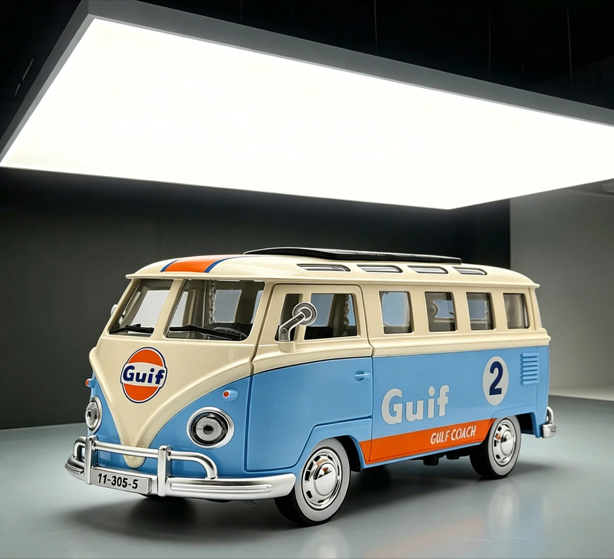 A vintage style metal bus diecast model in light blue and cream colors is displayed under bright lighting.