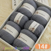 A box of 14 balls of grey wool yarn with wooden labels resting on a white background.