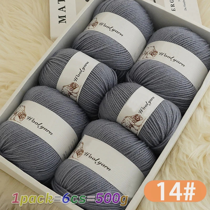 A box of 14 balls of grey wool yarn with wooden labels resting on a white background.