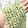 A hand holds a string of light green natural stone beads for DIY jewelry making