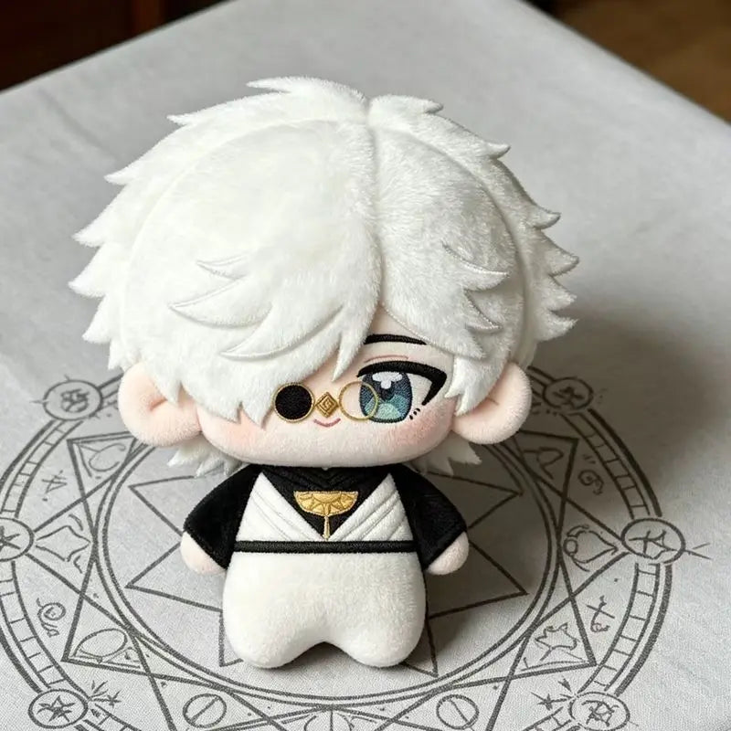 A white plush doll with light blue eyes and black clothing is displayed on a sheet of paper featuring a circular design.