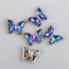 Gold-toned crystal butterfly charm beads with iridescent blue and purple stones for jewelry making