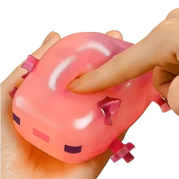 A hand is squeezing a pink, squishy toy shaped like an animated salamander fidget toy.