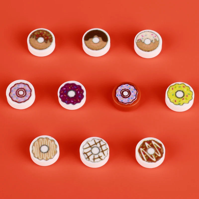 A collection of colorful mini food building blocks including pizza, cake, and condiment shaped pieces arranged in a row.