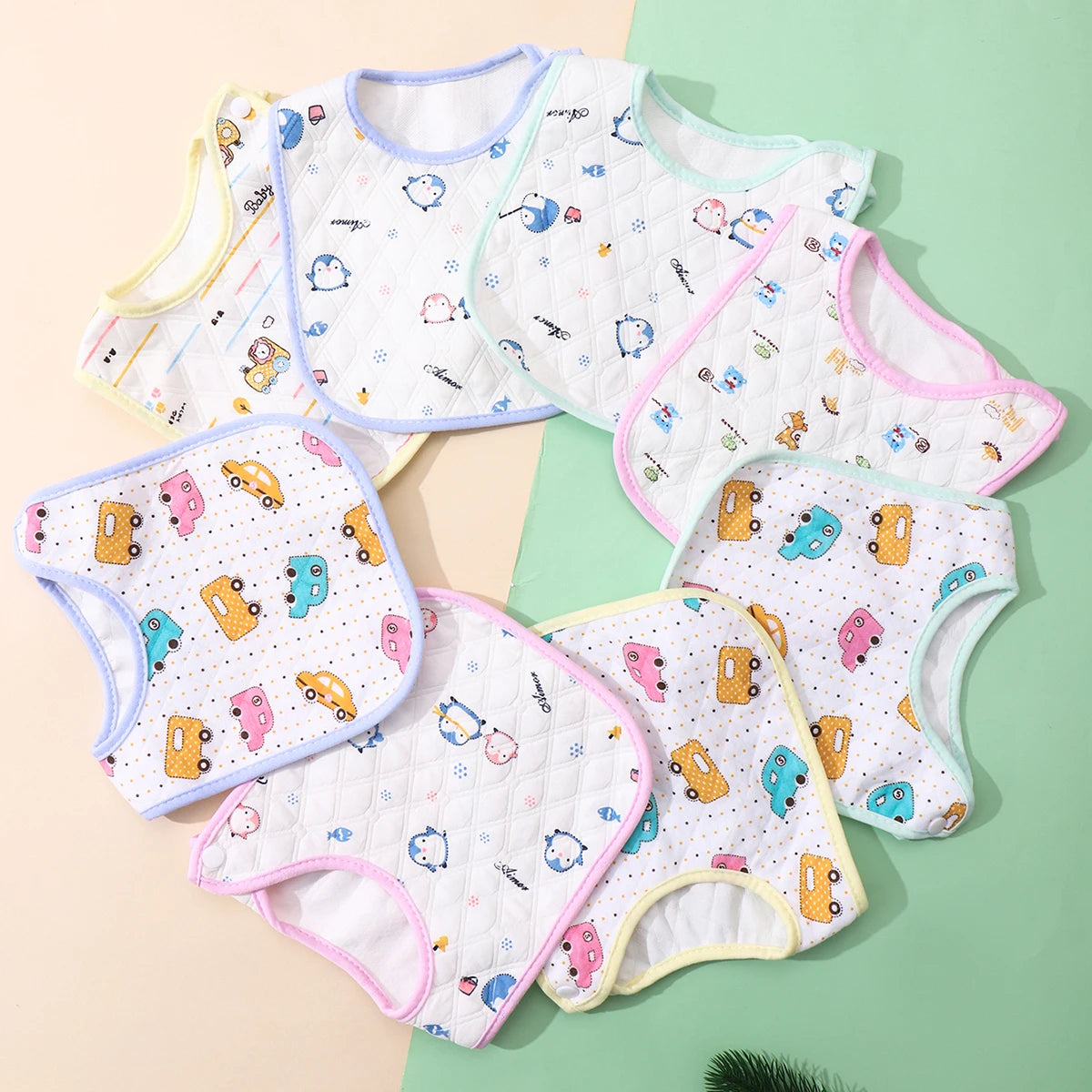 A pack of three white baby bibs with various cute illustrations and adjustable closures displayed on a light background.