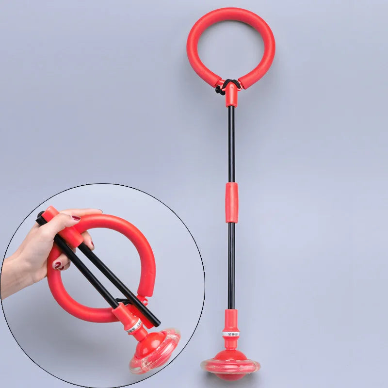 A red twist and jump ball with a tether is shown, being held by a hand against a light gray background.