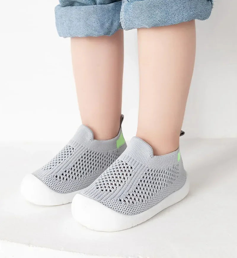 A pair of gray breathable mesh slip-on sneakers for toddlers are shown against a white background.