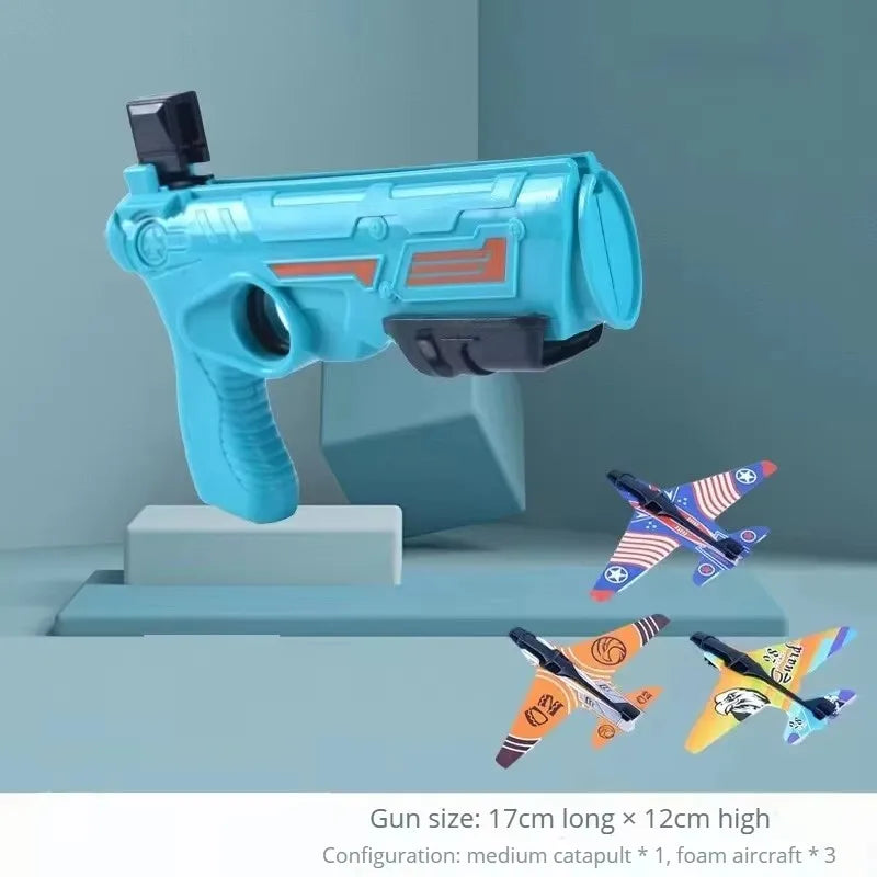 A light blue toy gun and three foam airplanes displayed on a gray surface.