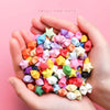 Hands holding a pile of colorful origami star strips for DIY crafting and decor