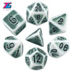 A collection of various polyhedral dice in shades of green and white.