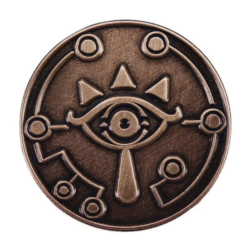 A round, bronze-colored enamel pin featuring a stylized eye design with radiating lines.