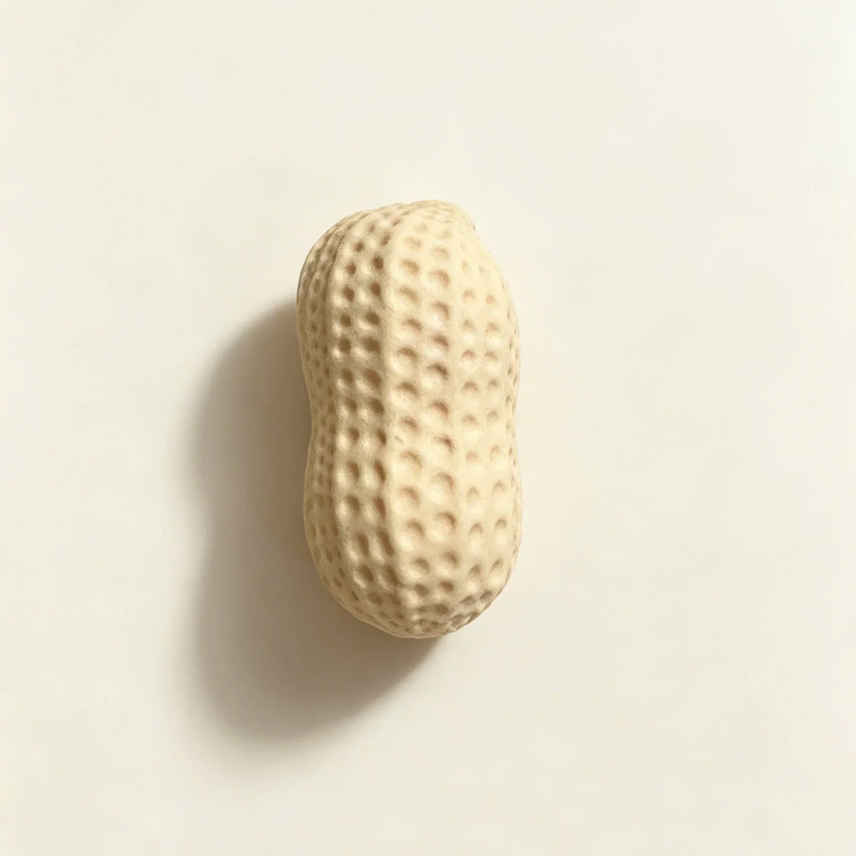A light beige, oval food-shaped squishy toy with a textured surface.