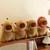 A row of three brown capybara plush toys sitting on a wooden shelf.