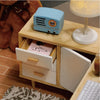 A light blue vintage-style radio sits on a wooden box next to a small wooden drawer kit.