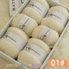 A box of six balls of white wool yarn for knitting, labeled as Merino Wool Yarn.