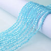 A close-up of light blue faceted glass crystal beads strung together, showing their texture and shine.