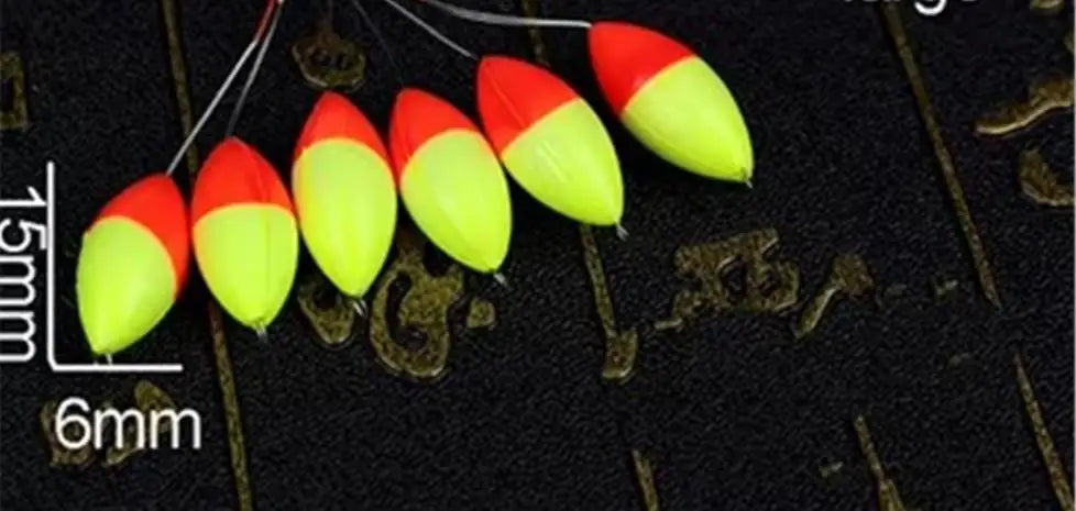 A row of bright red and yellow oval fishing floats with bobber beads are displayed against a dark background.