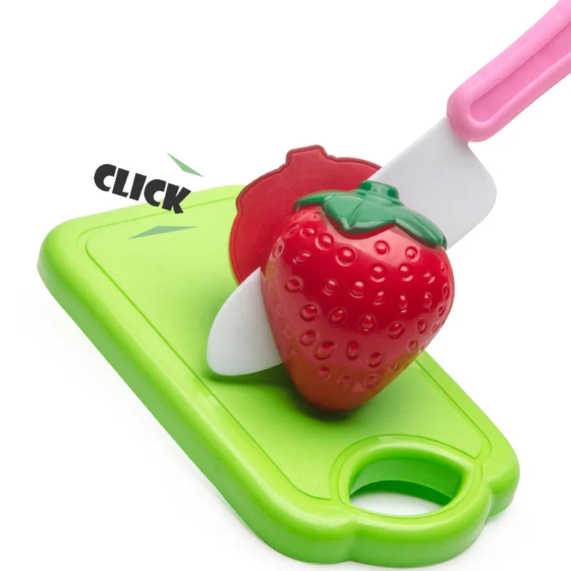 A pink plastic pretend play cutting set featuring a strawberry and other fruit shapes on a green cutting board.