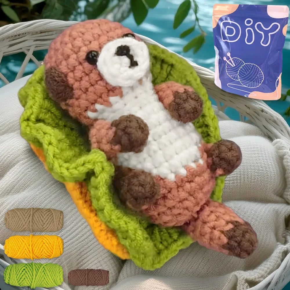 Un animal crochet terminé, ressemblant à un ours brun, est exposé sur un tissu vert sur fond blanc.