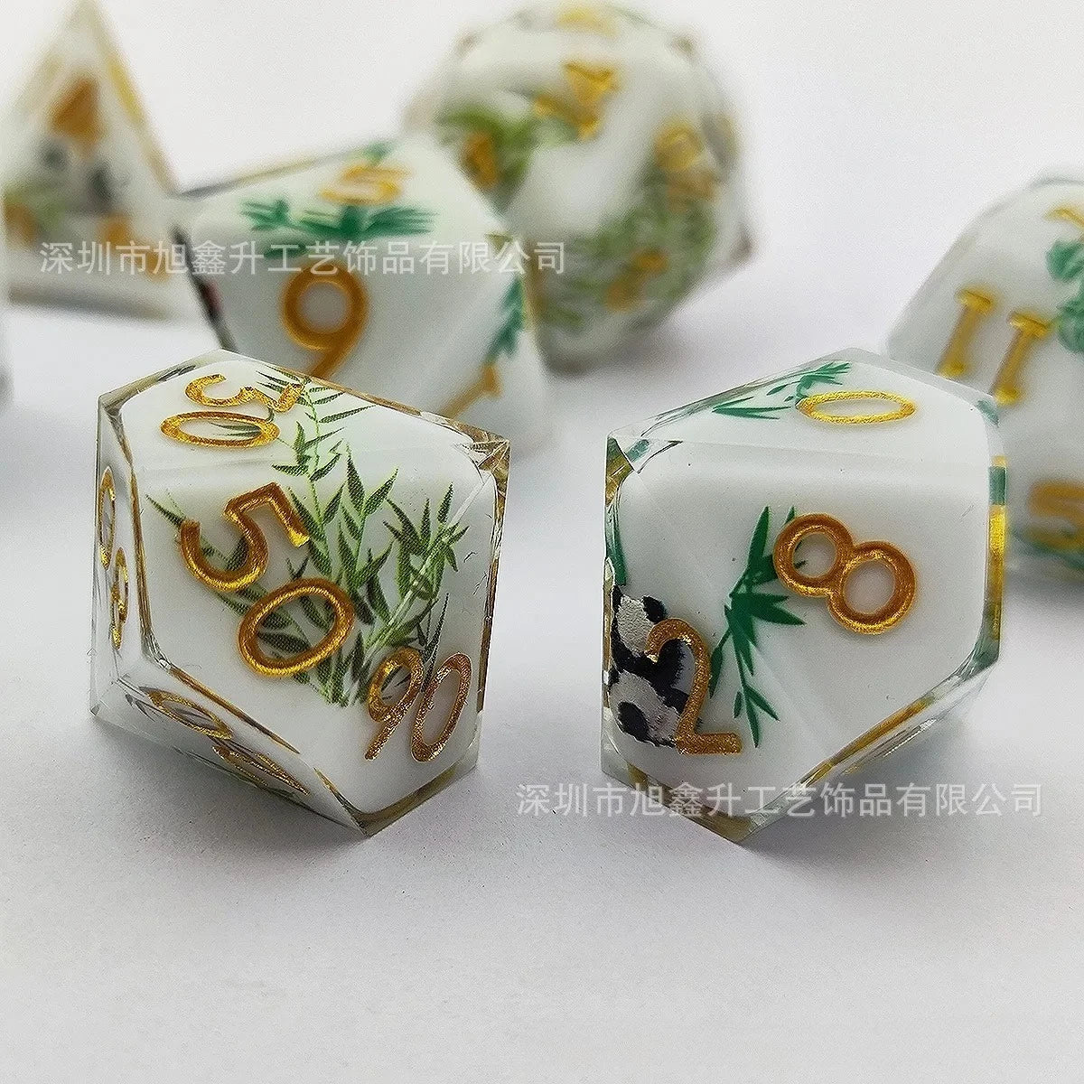 A set of milk white resin dice featuring gold numbers and green foliage with a black kitten design.