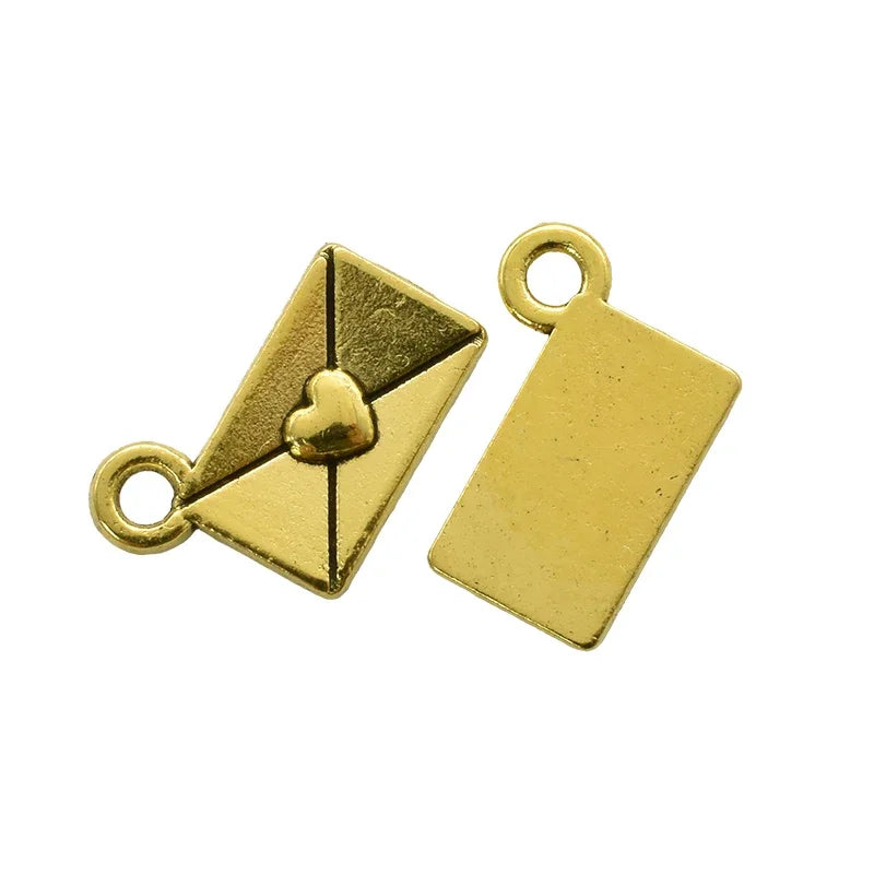 A pair of gold-colored vintage envelope charms, one featuring a heart design.