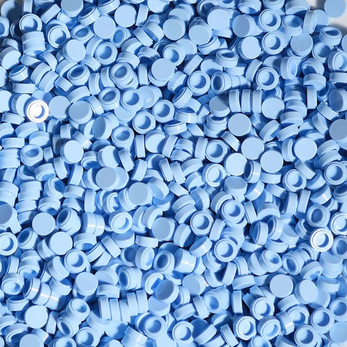 A pile of small, round, light blue plastic beads used for DIY squishy toys and stress relief crafts.
