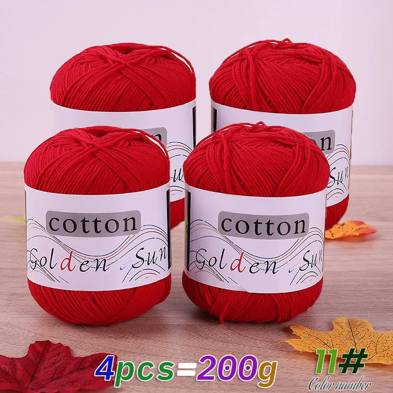 Four skeins of red cotton knitting yarn labeled Golden Sun for crafting projects