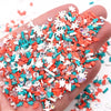 A hand holds a pile of colorful polymer clay slices in red, white, and teal for DIY crafts.