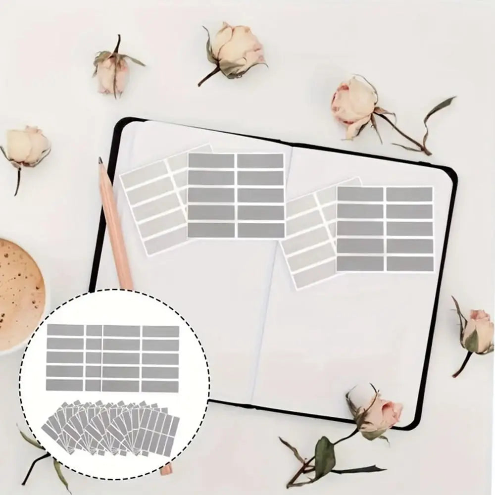 A flat lay showing scratch-off sticker sheets, various dried flowers, and a pencil on a white background.