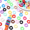A collection of colorful acrylic doughnut spacer beads in various shades including pink, green, yellow, and black.