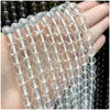 A hand holds a string of clear natural stone beads for DIY jewelry making.