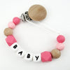 A necklace featuring silicone teething beads and a wooden clip, designed as a personalized pacifier clip.